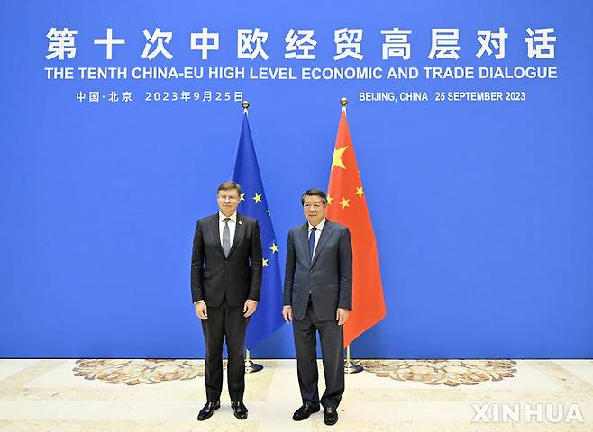 [베이징=신화/뉴시스] 26일(현지시간) 파이낸셜타임스(FT)에 따르면 발디스 돔브로우스키스 유럽연합(EU) 경제·통상 담당 수석 집행부위원장은  테슬라 등 중국에서 생산된 외국 전기차도 반보조금 조사 대상에 포함될 것이라고 밝혔다. 사진은 허리펑 중국 국무원 부총리(오른쪽)와 돔브로우스키스 부위원장이 베이징에서 기념사진을 촬영하는 모습. 2023.09.27