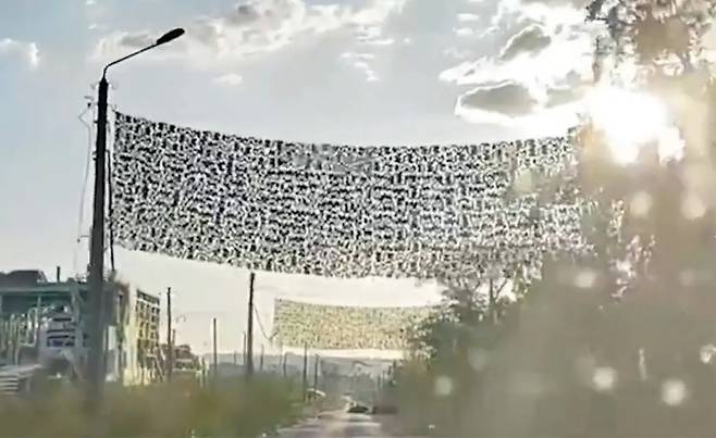 우크라이나의 동부 격전지 바흐무트의 한 도로 사이에 설치된 그물의 모습