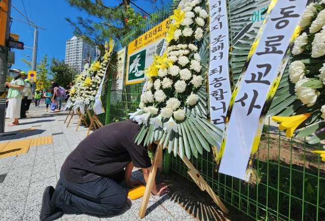 4년간 지속적인 악성 민원에 시달렸던 대전 유성구의 한 초등학교 교사가 극단적인 선택을 한 가운데, 한 동료 교사가 지난 8일 오후 숨진 교사가 근무했던 학교 앞에 놓인 추모 화환 앞에서 오열하고 있다. 연합뉴스