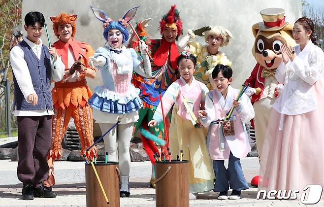 25일 부산 기장군 롯데월드 어드벤처 부산 야외무대 '가든 스테이지' 앞에서 한복을 입은 가족과 외국인 연기자들이 추석을 앞두고 투호놀이를 즐기고 있다. 2023.9.25/뉴스1 ⓒ News1 윤일지 기자