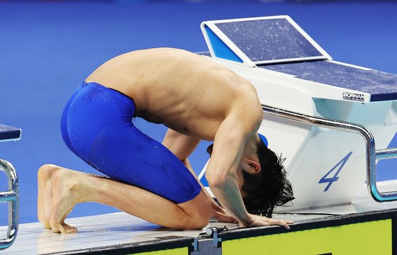 김우민이 29일 항저우 아시안게임 수영 남자 자유형 400m 우승으로 3관왕에 오른 뒤 관중석의 부모님을 향해 큰절을 하고 있다. 연합뉴스