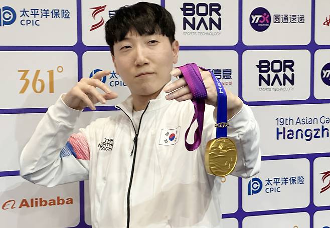 28일 중국 항저우 e스포츠센터에서 열린 2022 항저우 아시안게임(AG) 스트리트 파이터 V 결승전에서 대만의 샹여우린을 세트 점수 4-3으로 물리치고 금메달을 획득한 뒤 공동취재구역(믹스트존)에서 취재진을 향해 포즈를 취하고 있다. [연합]