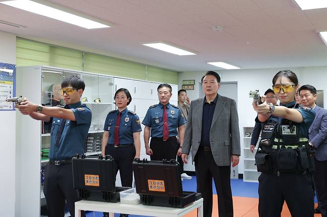 윤석열 대통령이 추석 연휴인 30일 서울 중부경찰서 을지지구대 시뮬레이션 사격장을 찾아 사격 훈련 시연을 참관하고 있다. /대통령실