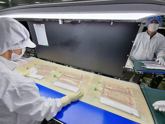 충남 당진 JW생명과학 수액공장 수액생산동에서 종합영양수액(TPN)이 컨베이어벨트를 통해 나오고 있다. 불투명한 부분이 동물성 지방을 따로 담은 것이다. 환자에게 치료하기 직전에 격막을 터뜨려 쓰게 된다. /남강호 기자