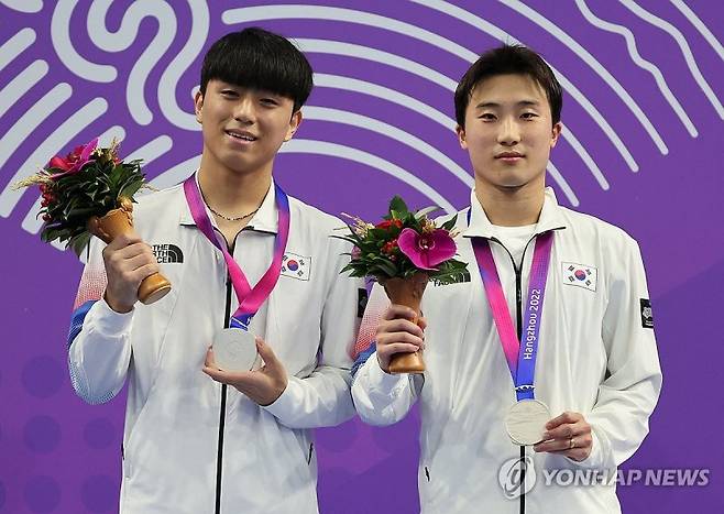 우하람-이재경 '이것이 은메달' (항저우=연합뉴스) 김인철 기자 = 9월 30일 중국 항저우 올림픽 스포츠센터 수영장에서 열린 19회 항저우 아시안게임 다이빙 남자 싱크로 3m 스프링보드 결승에서 은메달을 차지한 우하람(오른쪽), 이재경이 메달을 들어보이며 기념촬영하고 있다. 2023.9.30 yatoya@yna.co.kr (끝)