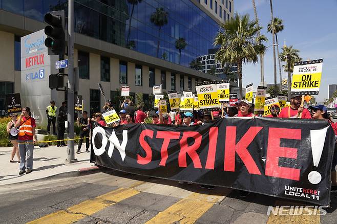 [로스앤젤레스=AP/뉴시스]미 로스앤젤레스의 넷플릭스 스튜디오 앞에서 지난 7월21일 파업 중인 '유나이트 히어 로컬 11' 호텔 직원들이 역시 파업을 벌이고 있는 미 배우·방송인노동조합(SAG-AFTRA) 및 미 작가조합(WGA)의 피케팅 시위에 동참하고 있다. 개빈 뉴섬 미 캘리포니아 주지사는 30일(현지시간) 파업 중인 근로자들에게 실업급여를 지급하는 내용의 법안에 대해 거부권을 행사했다. 이 법안은 헐리우드와 호텔 업계에서의 파업으로 주목을 받았었다. 2023.10.01.