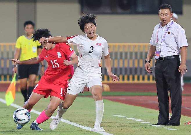 지난달 30일 중국 원저우 스포츠센터 스타디움에서 열린 2022 항저우 아시안게임 여자축구 8강전 한국과 북한의 경기. 후반 북한 리유일 감독이 대한민국 천가람과 북한 리명금의 볼다툼 모습을 바라보고 있다. 원저우=연합뉴스