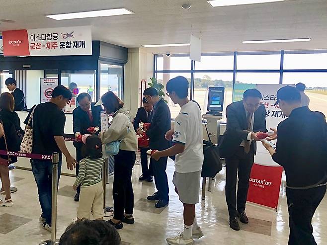 이스타항공, 군산∼제주 운항 재개 (서울=연합뉴스) 1일 군산공항 ZE301편 게이트 앞에서 이스타항공 조중석 대표를 비롯한 임직원이 승객들에게 선물을 나눠주고 있다. 2023.10.1. [이스타항공 제공. 재판매 및 DB 금지]