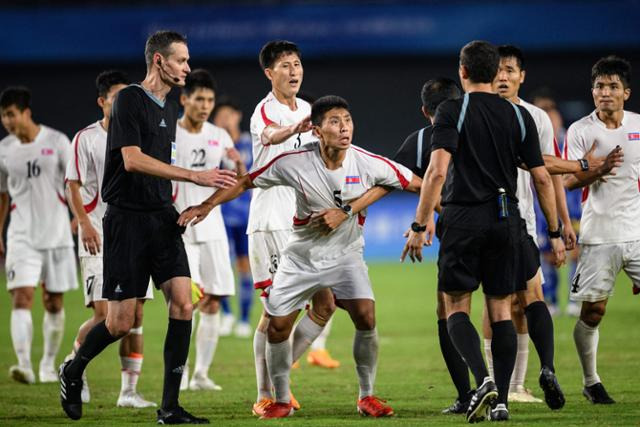 북한 축구대표팀의 일부 선수들이 3일 중국 샤오산 스포츠센터 스타디움에서 열린 일본과의 8강전이 끝난 뒤 주심을 향해 강하게 항의하고 있다. 북한은 이날 주심의 페널티킥이 선언되면서 일본에 1-2로 패했다. AFP 연합뉴스