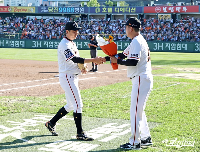 한화 정우람(왼쪽)이 2일 대전 NC전에서 통산 1000경기 등판 기록을 세운 후 최원호 감독에게 꽃다발을 받고 있다. /사진=한화 이글스