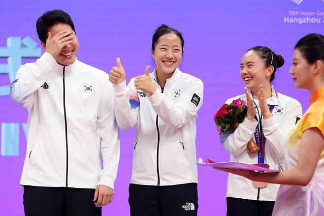 30일 중국 항저우 궁수 캐널 스포츠파크 체육관에서 열린 2022 항저우 아시안게임 혼합복식 시상식에서 동메달을 획득한 신유빈(가운데)이 같은 조 임종훈(맨 왼쪽)에게 엄지손가락을 치켜세우고 있다. 맨 오른쪽은 전지희./뉴시스