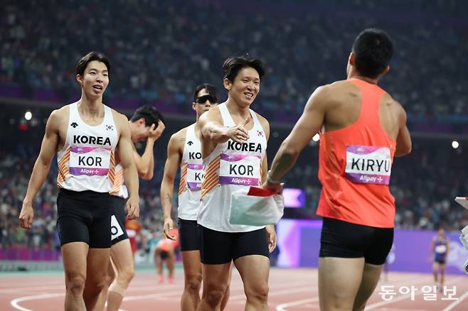 한국 육상 김국영(오른쪽에서 두 번째)이 3일 중국 항저우 올림픽센터 체육관에서 열린 항저우 아시안게임 남자 400m 계주 결선에서 동메달을 딴 뒤 은메달을 획득한 일본의 키류 요시히데 선수(오른쪽 첫 번째)와 악수를 하려 하고 있다. 항저우= 김재명 기자base@donga.com