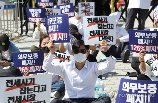 전국임대인연합회가 지난달 22일 오전 서울 용산구 대통령실 인근에서 연 '역전세 유도·파산 강요 중단 촉구' 집회에서 참가자들이 손팻말을 들고 있다. 사진 연합뉴스