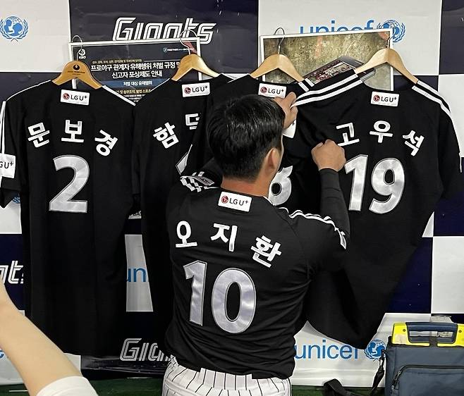 더그아웃에 함께하지 못하는 동료 유니폼을 거는 LG 오지환 [촬영 이대호]