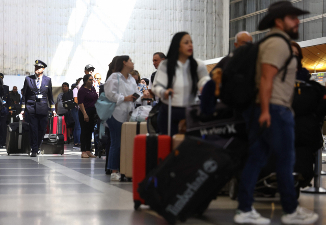 여행객들이 미국 캘리포니아 LA공항을 걸어가고 있다. 치솟는 채권금리에 기업과 가계의 자금 조달 비용이 커지면서 미국 경제가 연착륙하지 못할 수 있다는 우려가 커지고 있다. AFP연합뉴스
