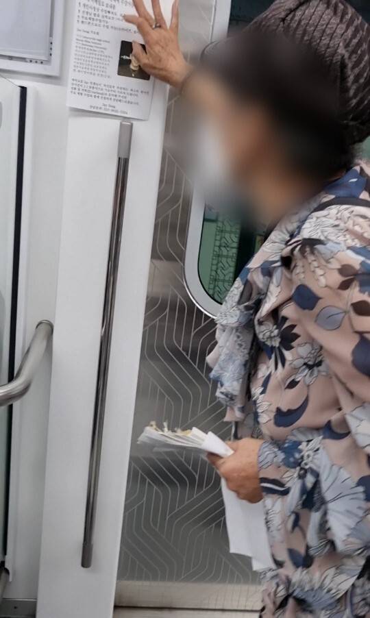 지하철 열차 내에 불법 전단을 부착하는 모습(제공=서울교통공사)