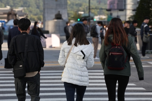 쌀쌀한 가을 날씨를 보인 5일 서울 종로구 광화문네거리에서 외투와 긴팔 옷을 입은 시민들이 발걸음을 재촉하고 있다.  연합뉴스