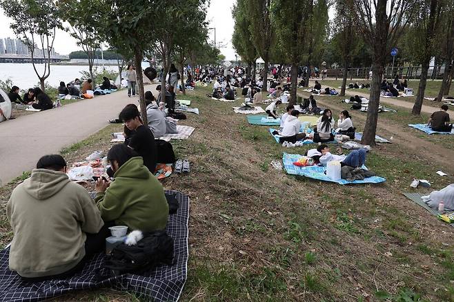 7일 오후 ‘서울세계불꽃축제 2023’를 구경하기 위해 나온 시민들이 서울 용산구 이촌한강공원에서 돗자리에 앉아 불꽃축제를 기다리고 있다. 강창광 선임기자