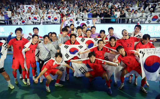 항저우 아시안게임 남자 축구 결승서 일본을 2대1로 꺾고 우승을 차지한 한국 선수들이 태극기를 펼쳐들고 기념촬영을 하고 있다.연합뉴스