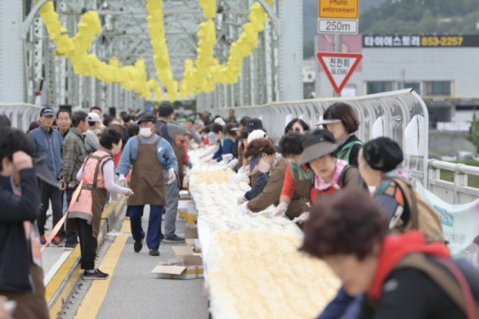 7일 충남 공주시 금강철교 위에서 열린 ‘인절미 축제’에서 시민과 관광객들이 인절미를 만들고 있다. 연합뉴스