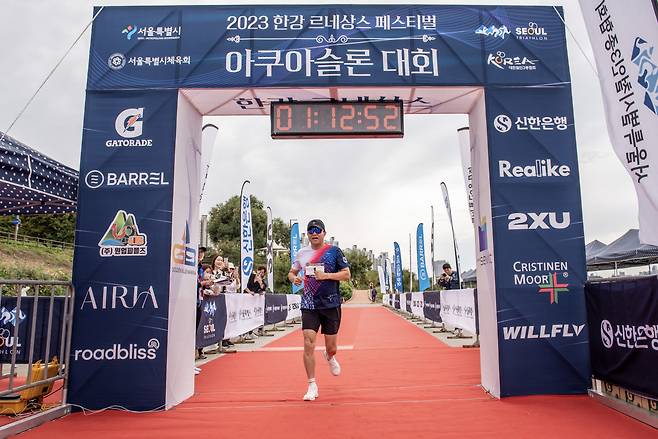 오세훈 서울시장이 8일 서울 송파구에서 열린 '2023 한강 르네상스 페스티벌 아쿠아슬론대회' 챌린지코스 달리기에 참가해 결승선으로 들어오고 있다. [연합]