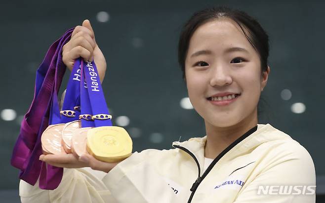 [인천공항=뉴시스] 김근수 기자 = 2022 항저우 아시안게임 대한민국 여자 탁구 대표팀 신유빈이 8일 인천국제공항 제1여객터미널 입국장에서 열린 환영행사에서 메달을 들어 보이고 있다. 2023.10.08. ks@newsis.com