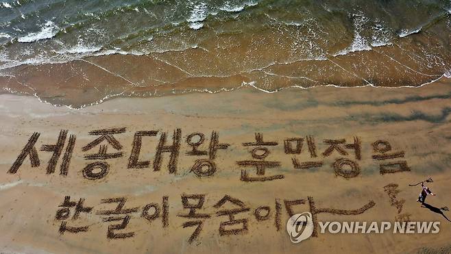 "한글이 목숨이다" (포항=연합뉴스) 서예가 쌍산 김동욱씨가 한글날을 앞두고 7일 경북 포항시 북구 영일대해수욕장에서 모래에 갈고리로 "세종대왕 훈민정음 한글이 목숨이다"란 문구를 쓰는 행위예술을 하고 있다.2022.10.7 [김동욱씨 제공. 재판매 및 DB 금지] sds123@yna.co.kr