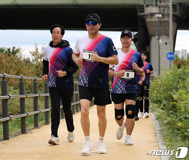 오세훈 서울시장이 8일 서울 송파구 잠실한강공원에서 열린 ‘2023 한강 르네상스 페스티벌 아쿠아슬론 대회’ 개인전 챌린지 코스에 선수로 참가해 일반 참가자들과 5km 달리기를 하고 있다. 2023.10.8/뉴스1 ⓒ News1 김진환 기자