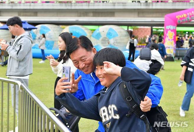 [장성=뉴시스] 이창우 기자=김한종 장성군수가 장성 황룡강 가을꽃축제장을 찾은 어린이와 기념사진을 남기고 있다. (사진=장성군 제공) 2023.10.09. photo@newsis.com