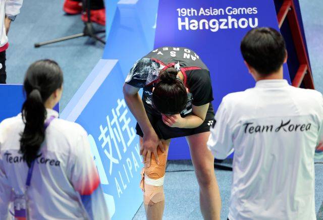 지난 7일 중국 항저우 빈장체육관에서 열린 항저우 아시안게임 배드민턴 여자 단식 결승에서 금메달을 획득한 한국 안세영이 통증이 있는 무릎을 손으로 부여잡고 감격의 눈물을 흘리고 있다.연합뉴스