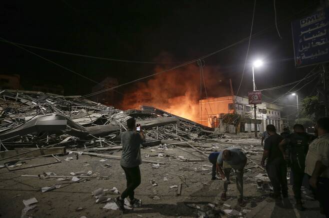 팔레스타인 사람들이 이스라엘의 가자지구 공습 여파를 보고 있다. /연합·EPA