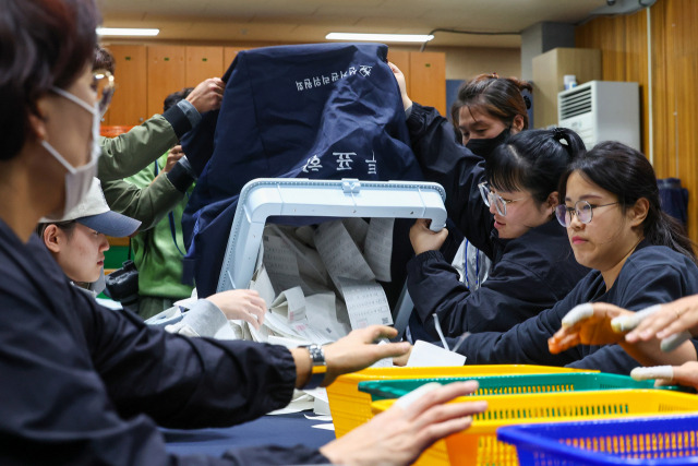 서울 강서구청장 보궐선거일인 11일 오후 서울 강서구 마곡레포츠센터실내배드민턴장에 마련된 개표소에서 개표사무원 등 관계자들이 개표작업 시작을 위해 투표함을 개함하고 있다. 연합뉴스