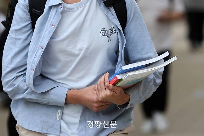 서울 강남 대치동 학원가에서 한 학생이 지난달 24일 교재를 들고 학원으로 향하고 있다. 조태형 기자