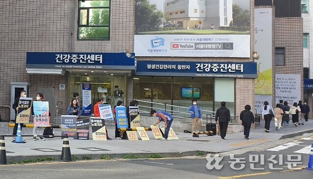 12일 오전 7시 서울대병원 정문 앞에 모인 노조 조합원들이 표어를 들고 구호를 외치고 있다. 임태균 기자