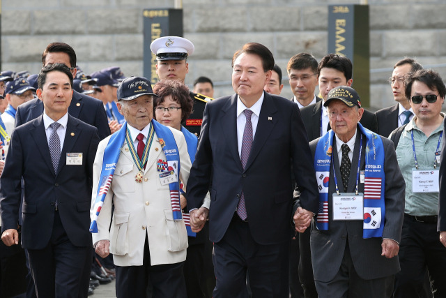 윤석열 대통령이 12일 오후 서울 용산 전쟁기념관 평화의광장에서 열린 제73주년 장진호 전투 기념행사에 6·25 참전용사와 함께 입장하고 있다./연합뉴스