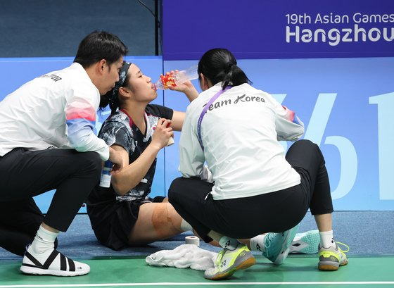 항저우 아시안게임 여자 단식 경기 도중 무릎 통증으로 인해 응급 치료를 받는 안세영(가운데). 연합뉴스