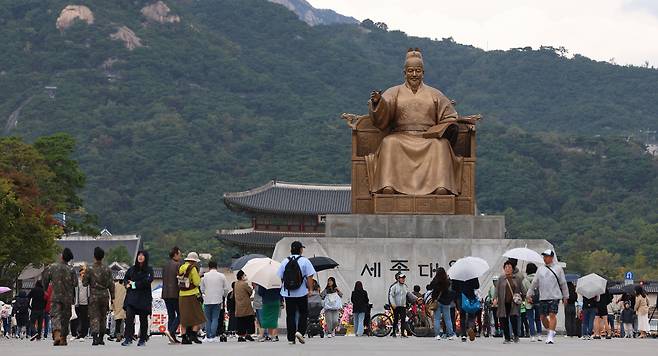 서울 광화문광장을 찾은 시민들이 세종대왕 동상 앞을 지나고 있다. [연합]