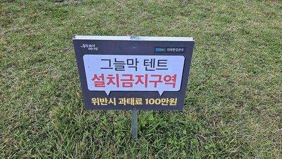 서울 여의도 한강공원에 설치된 '그늘막 텐트 설치 금지 구역' 팻말. 위반 시 과태료 100만원이 부과될 수 있다. 장서윤 기자