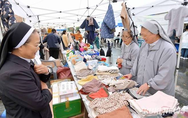 수녀님들이 서울카톨릭사회복지회에서 운영하는 부스에서 자신의 성당 교인 자녀들에게 선물할 옷을 고르고 있다.