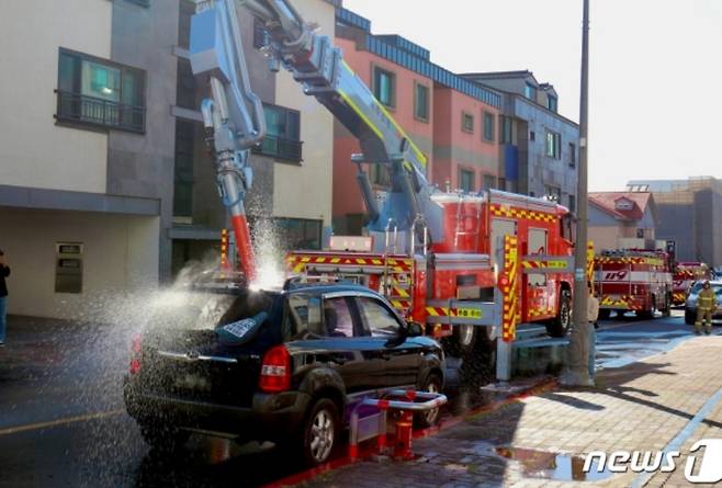 제주소방대원들이 12일 실제 폐차 차량을 동원해 소방차량 통행을 막는 불법 주차 차량에 대한 강제처분 훈련을 하고 있다./사진=뉴스1