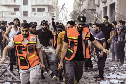 이스라엘의 지상전 전개가 임박하고 이란의 개입 가능성이 고조된 가운데, 이스라엘측과 팔레스타인 가자지구에서의 인명피해가 급속히 늘고 있다. 이스라엘과 하마스간 전쟁이 아흐레째인 15일(현지시간) 이스라엘 남부 크파르 아자 키부츠 주민이 “당신은 결코 혼자가 아닙니다”라고 쓰인 영국 프로축구클럽 리버풀의 응원 슬로건 포스터를 들고 있다(위쪽). 이날 가자지구 북부 라파에서 구조대가 이스라엘의 폭격으로 사망한 주민의 시신을 옮기고 있다. [AFP]