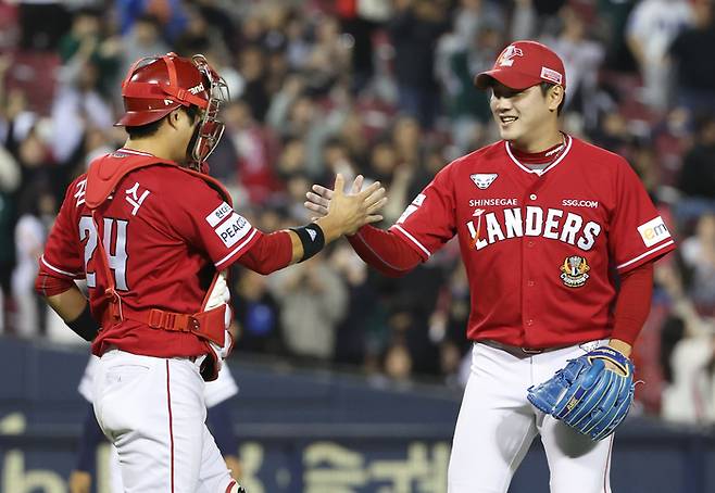 SSG 마무리 서진용(오른쪽)이 16일 잠실 두산전에서 3-2 팀 승리를 지킨 뒤 포수 김민식과 하이파이브하고 있다. 연합뉴스