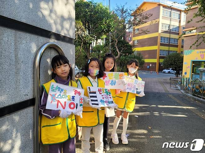 교통안전 포스터를 들고 있는 광일초 학생들의 모습(광일초 녹색어머니회 제공)