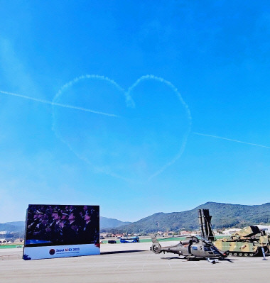 17일 경기도 성남 서울공항에서 열린 '서울 아덱스(ADEX) 2023' 개막식에서 블랙이글스가 연막으로 하늘에 하트를 그린 뒤 이를 관통하는 큐피드의 화살을 선보이고 있다. 아덱스 개막식 영상 갈무리