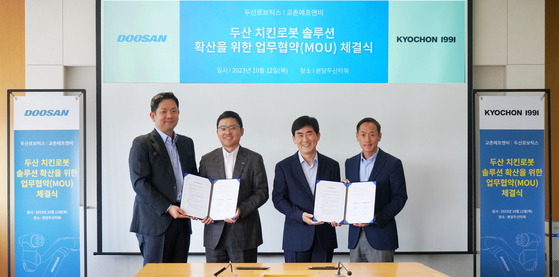 From right, Doosan Robotics Co-CEO Park In-won, Kyochon F&B vice-president Song Jong-hwa, Doosan Robotics Co-CEO Ryu Jung-hoon and Kyochon F&B CEO Yoon Jin-ho pose for a photo after the MOU signing on Monday. [JOONGANG ILBO]