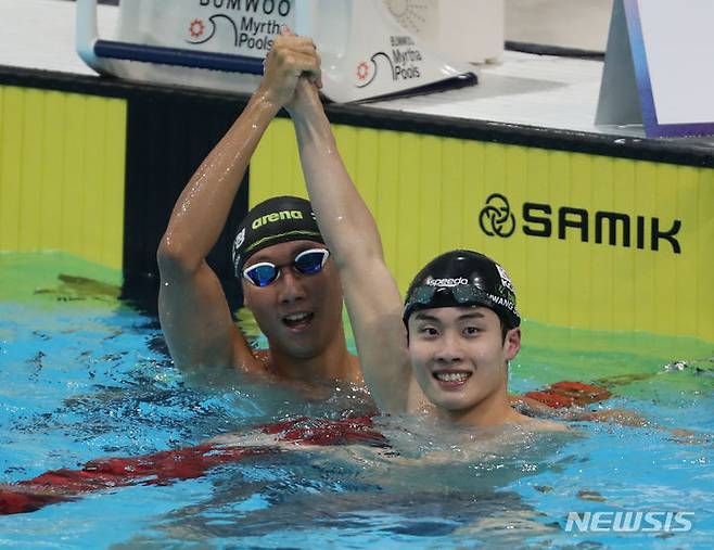 [목포=뉴시스] 김근수 기자 = 전국체전에서 3관왕을 차지한 황선우(강원)가 18일 전남 목포시 목포실내수영장에서 열린 제104회 전국체육대회 수영 남자 자유형 100m 결선경기에서 김민준(강원)과 기쁨을 나누고 있다. 이번 종목 우승으로 황선우는 남자 일반부 계영 800ｍ·자유형 200ｍ·계영 400m에 이어 4관왕을 차지했다. 2023.10.18. ks@newsis.com