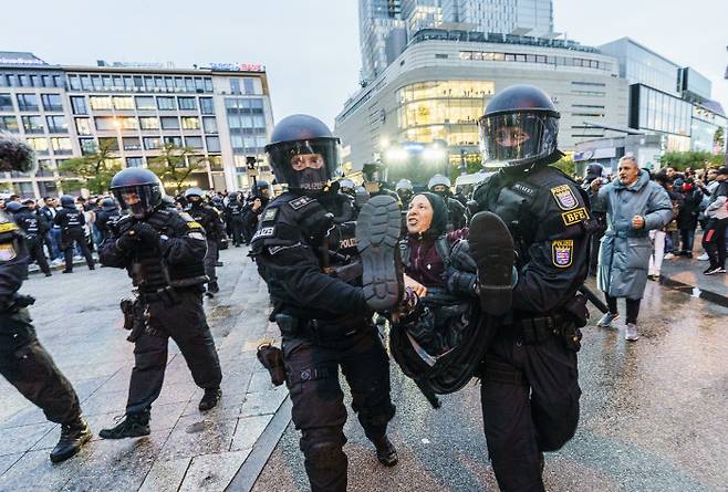독일 경찰들이 18일(현지시간) 프랑크푸르트에서 친팔레스타인 시위를 벌이던 한 여성을 안아서 옮기고 있다. AP연합뉴스
