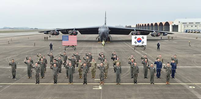 Chairman of the Joint Chiefs of Staff Kim Seung-kyum (center, front row), South Korean Air Force Chief of Staff Gen. Jung Sang-hwa (fourth from left, front row) and US Pacific Air Forces Commander Kenneth Wilsbach (fourth from right, front row) pose for a photo in front of the nuclear-capable US strategic bomber B-52H that landed in Korea for the first time, at the Air Force base in Cheongju, North Chungcheong Province, Thursday. (Joint Chiefs of Staff)