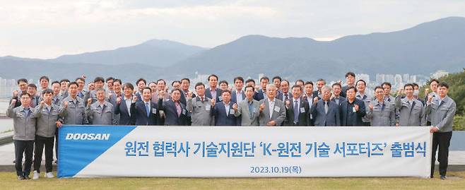 지난 19일 두산에너빌리티 경남 창원 본사에서 열린 ‘K-원전 기술 서포터즈’ 출범식에서 정연인 두산에너빌리티 사장(앞줄 오른쪽 세번째)과 박봉규 원비두기술 데표(앞줄 왼쪽 일곱번째) 등 참석자들이 기념촬영을 하고 있다.(사진=두산에너빌리티)