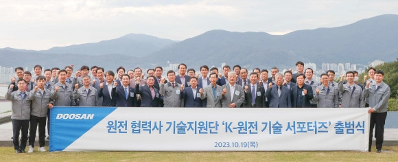 두산에너빌리티 창원 본사에서 19일 열린 ‘K-원전 기술 서포터즈’ 출범식에서 두산에너빌리티 정연인 사장(앞줄 우측 3번째)과 원비두기술 박봉규 대표(앞줄 좌측 7번째) 등 참석자들이 기념촬영을 하고 있다. 두산에너빌리티 제공